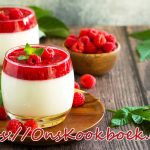 Twee glaasjes panna cotta met verse frambozen als zomers dessert
