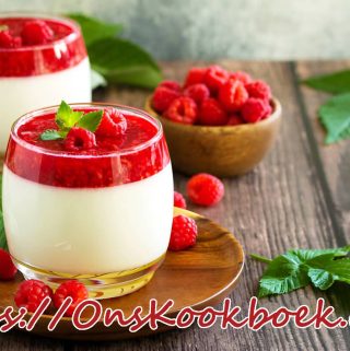 Twee glaasjes panna cotta met verse frambozen als zomers dessert