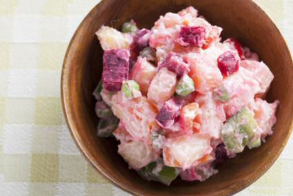 Een bord met rode bieten salade, aardappels en een yoghurt dressing met verse tuinkruiden