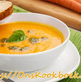 Romige wortelsoep uit Dagelijkse Kost geserveerd met brood, pesto en basilicum