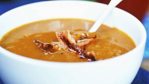 Kom pompoensoep volgens het recept van Jeroen Meus, geserveerd met spekjes