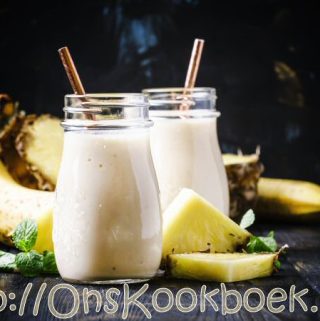 risse ananas smoothies met banaan in glas met rietje, snelle zomerse drank met fruit