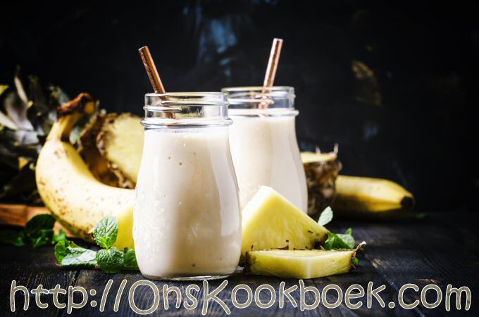 risse ananas smoothies met banaan in glas met rietje, snelle zomerse drank met fruit