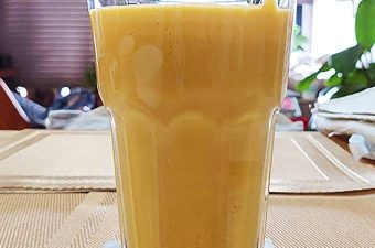 Mango lassi smoothie in glas met ijs, frisse drank bij warm weer