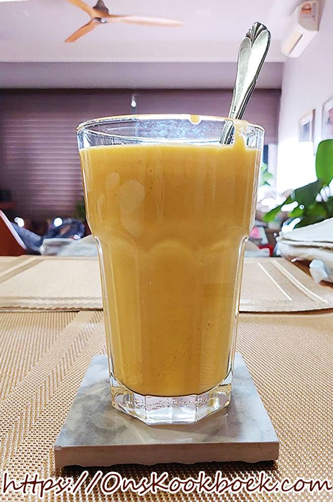 Mango lassi smoothie in glas met ijs, frisse drank bij warm weer