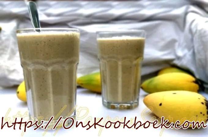 2 glazen vegetarische en lactosevrije mango smoothies met op de achtergrond verse mangos