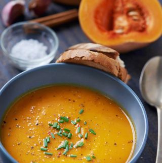 Kom romige pompoensoep volgens recept van Piet Huysentruyt, geserveerd met brood