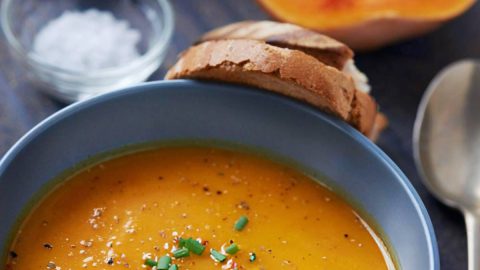 Kom romige pompoensoep volgens recept van Piet Huysentruyt, geserveerd met brood