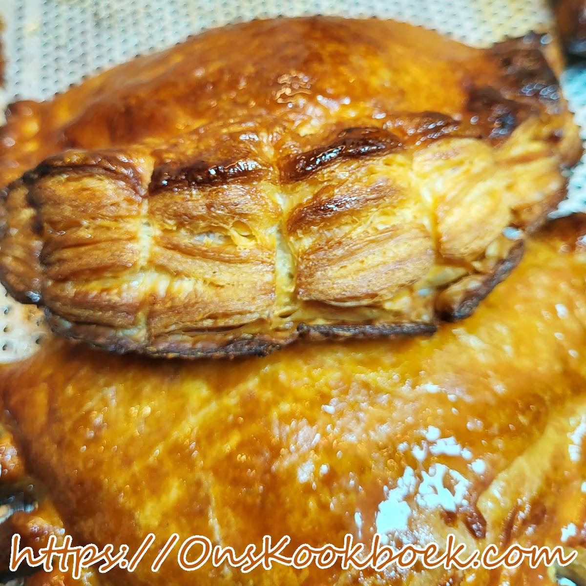 Close-up van een luchtige appelflap met knapperige laagjes bladerdeeg