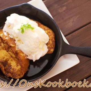 Goudbruin gewonnen brood met appel en speculaas in een pan, geserveerd met ijs