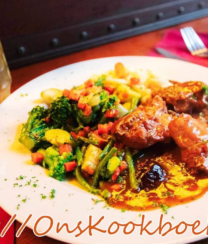 Konijn met pruimen en bier in Vlaamse saus, geserveerd met groenten en saus