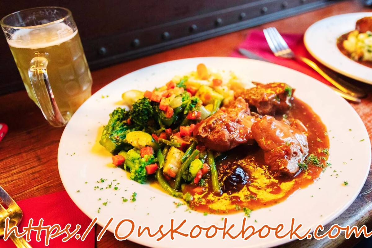 Konijn met pruimen en bier in Vlaamse saus, geserveerd met groenten en saus