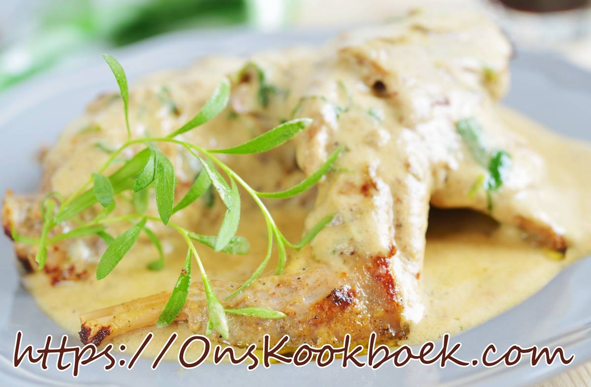 Konijnenbouten uit de oven onder een romige mosterdsaus, geserveerd met takje dragon op wit bord